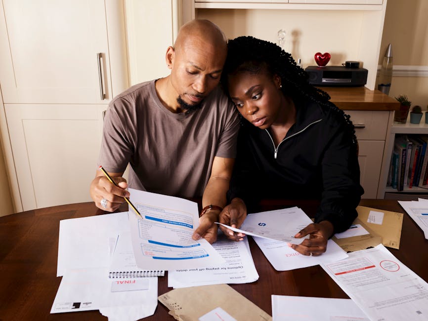A couple sitting at a table reviewing financial documents, highlighting domestic budgeting.
