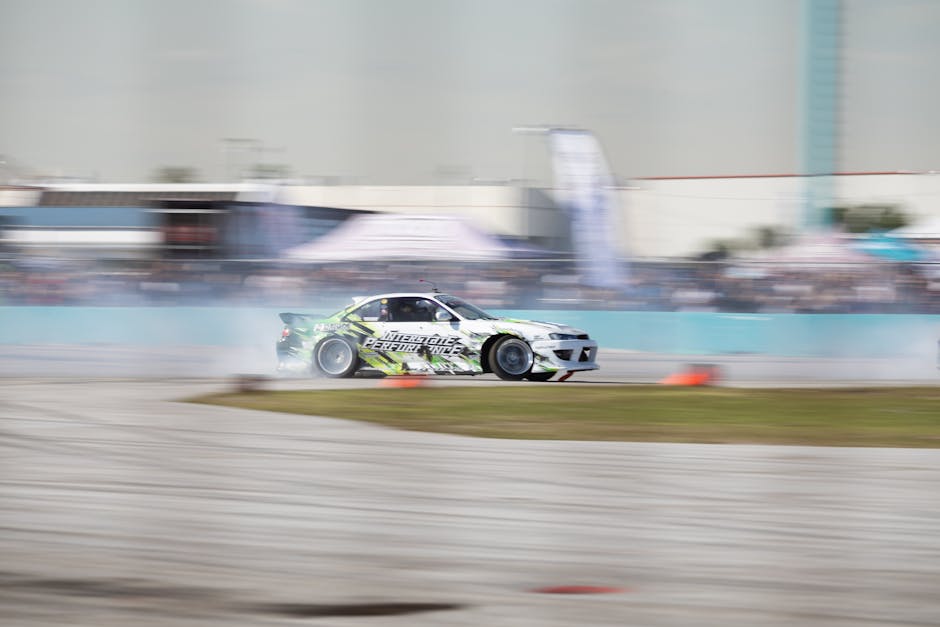 A high-speed car drifting around a race track corner with motion blur effect.