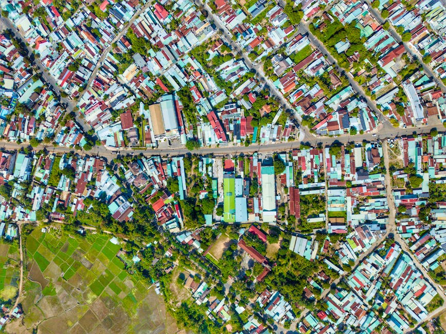 Aerial shot of a colorful urban neighborhood, showcasing tightly packed houses and greenery.
