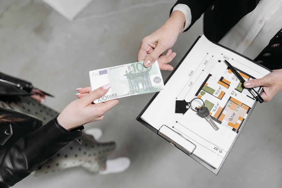 Close-up of a real estate transaction with euro bill, keys, and floor plan.