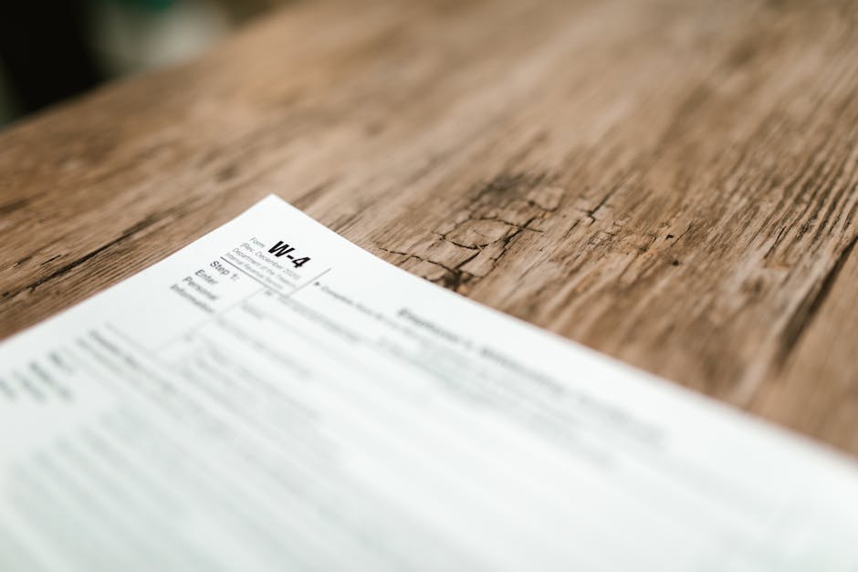 Close-up of a W-4 form resting on a rustic wooden table, highlighting textures.