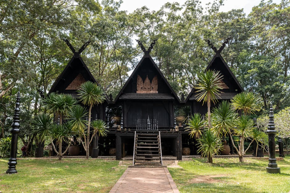 Traditional Thai structure amidst lush greenery, showcasing unique architecture in Chiang Rai, Thailand.