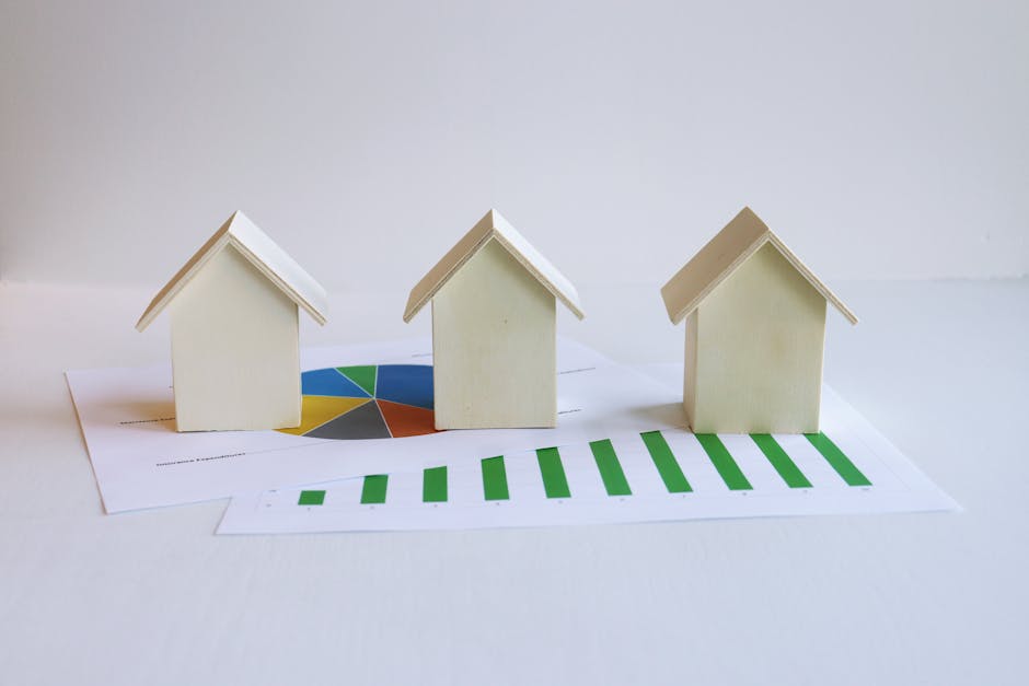 Wooden model houses on graphs depict real estate market analysis and trends.